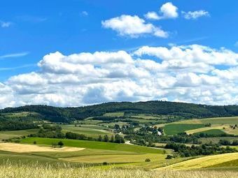 Weite Landschaften umgeben von zarten Hügelketten.